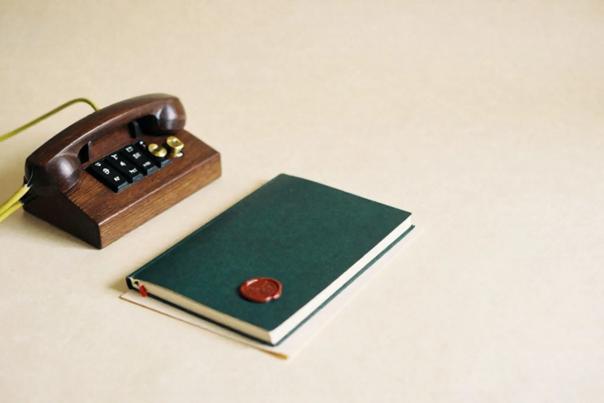 Wooden telephone switchboard with brass patch cables, one green cord, folded letter, ink ledger, red wax seal on ivory paper.