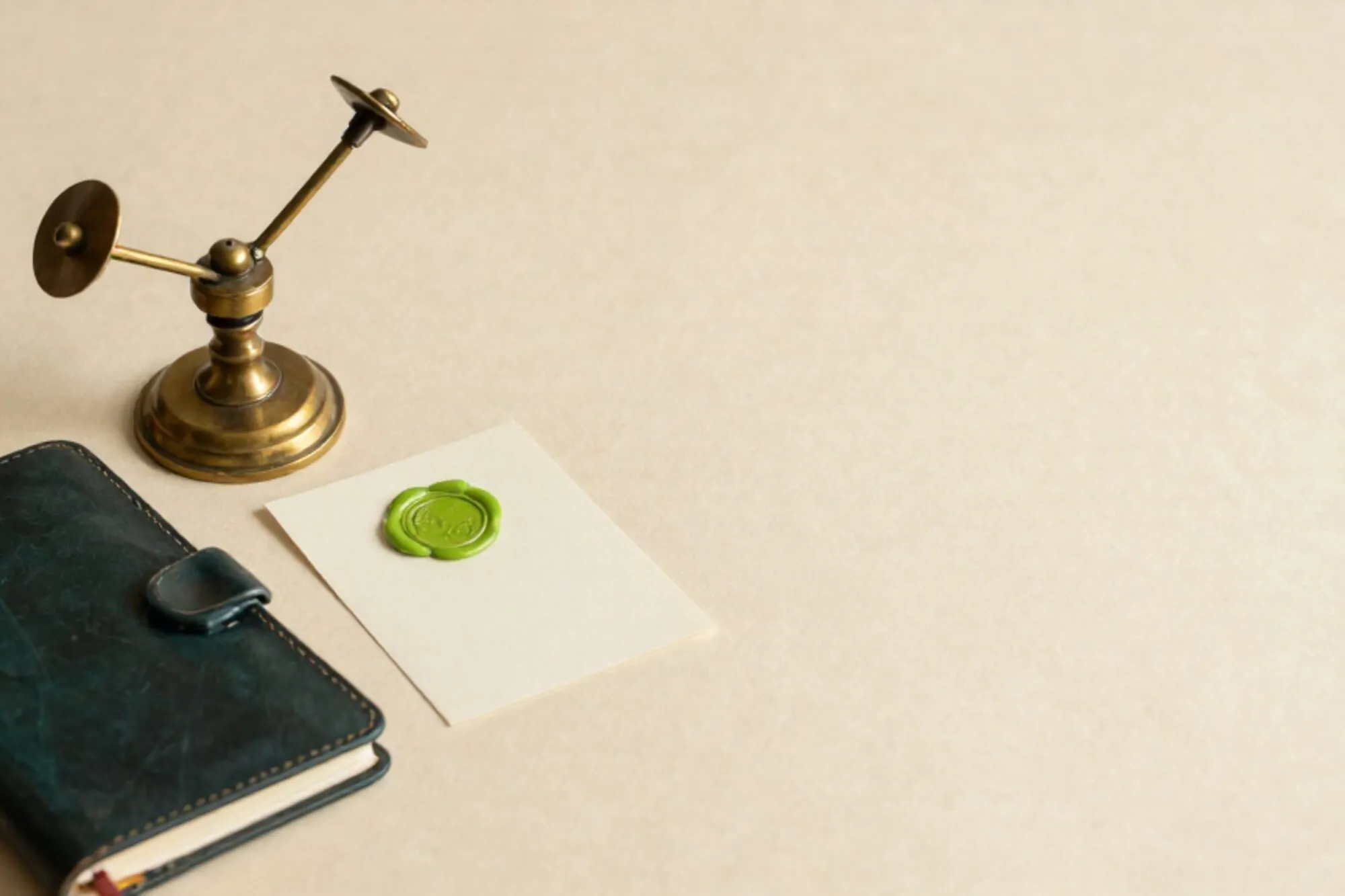Messing semafoorhendel op ivoorpapier, kaart met groene lakzegel, donker leren notitieboek, rode draad om messing speld.