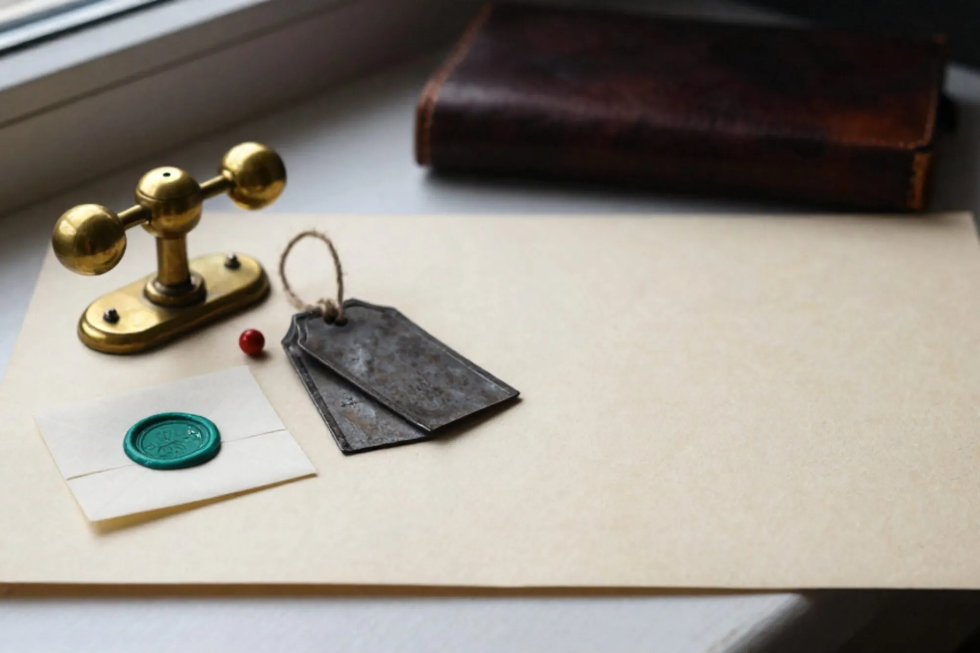 Brass three-way railway lever on ivory blotter, folded telegraph slip with chartreuse wax seal, iron shipping tags, red pin.
