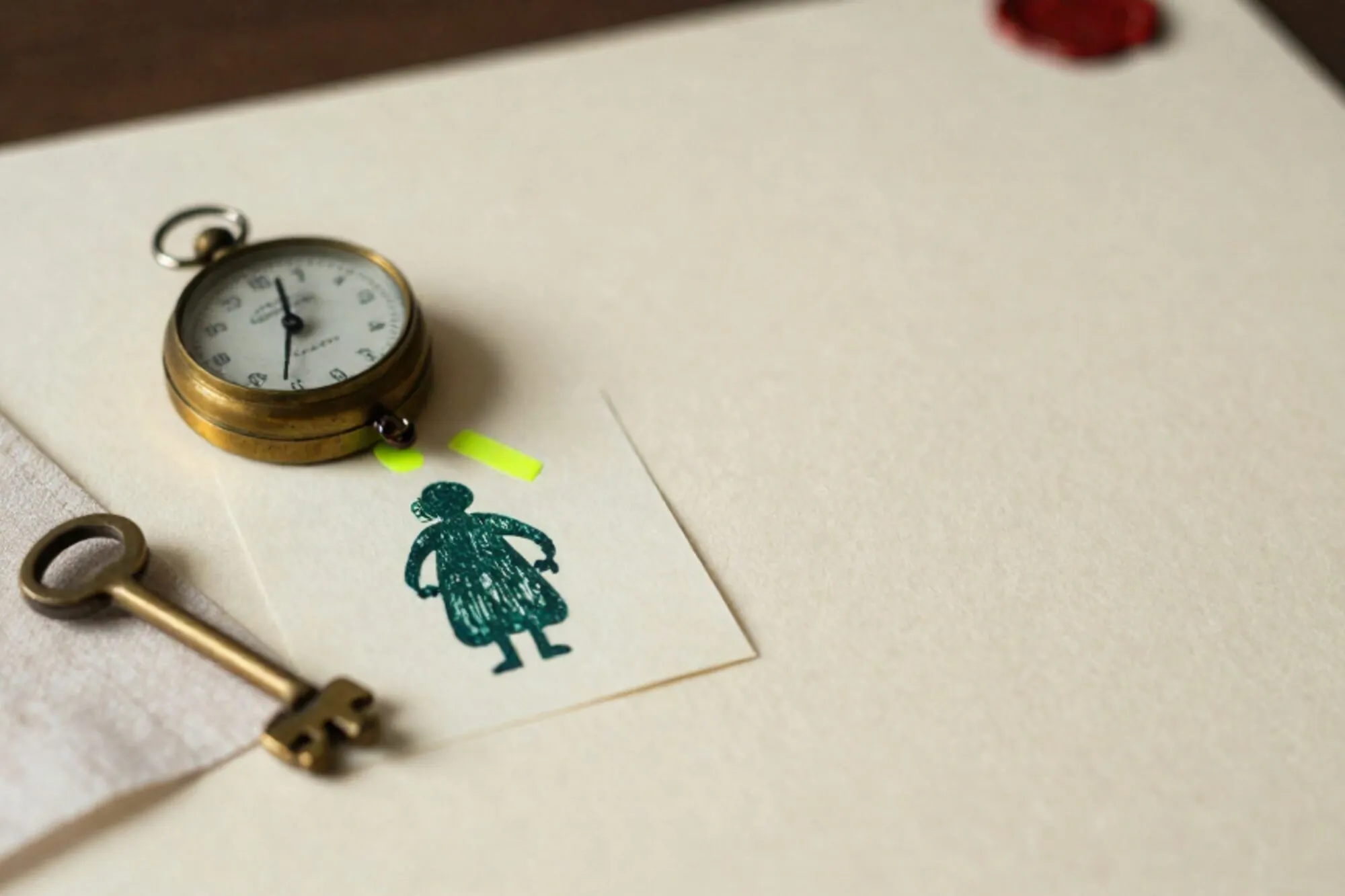 Messing telwiel, crème formulier met groene inktstempel, chartreuse tab, messing sleutel op linnen, ivoor papier.