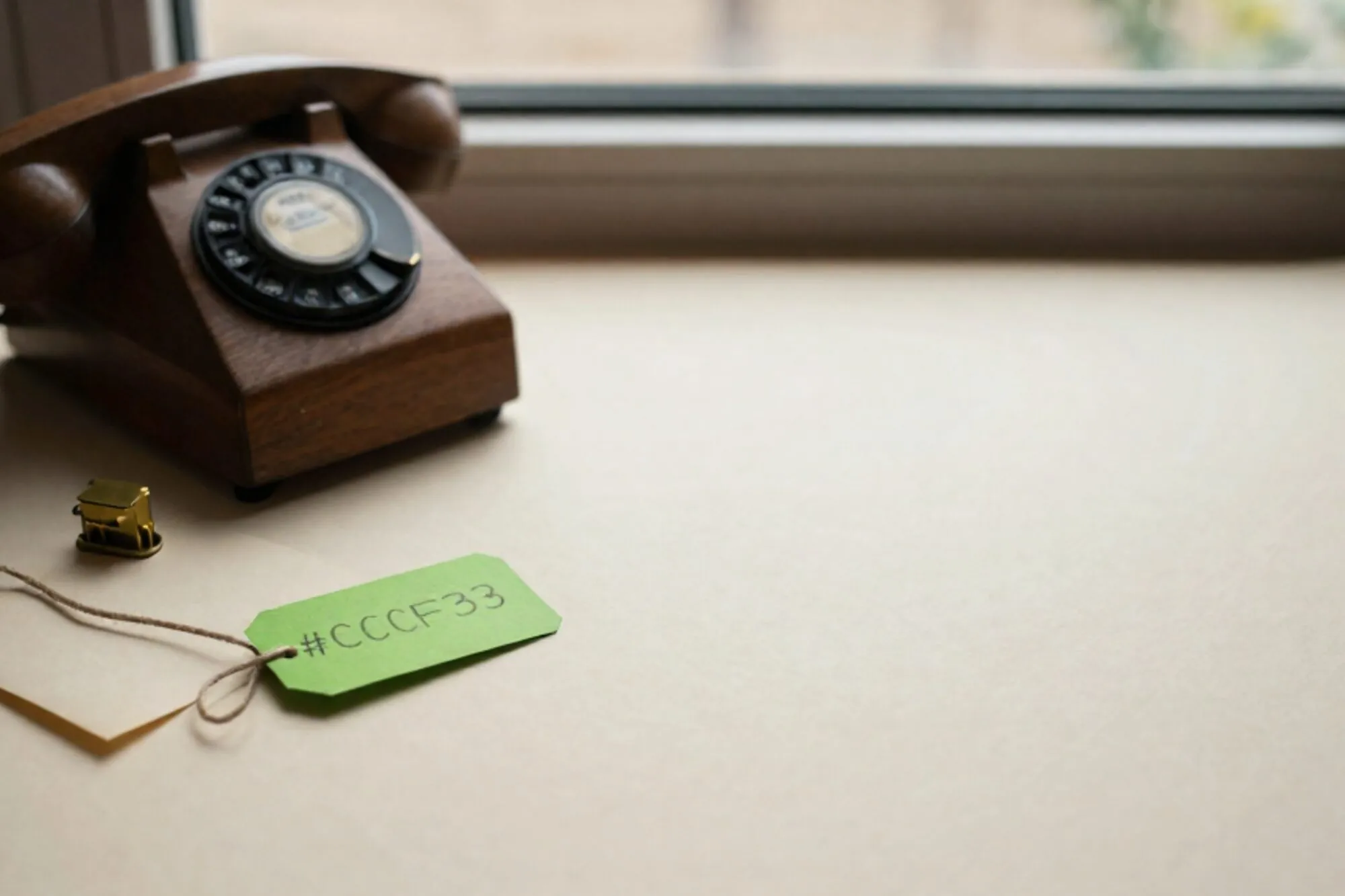 Wooden manual telephone switchboard with brass jacks and cloth cords on ivory paper, one cord tagged chartreuse green.