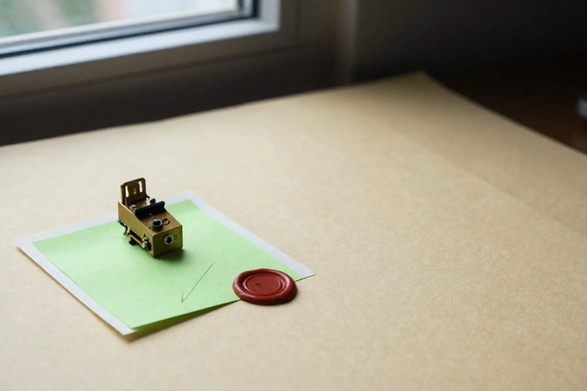 Brass relay switch on folded ivory paper form, chartreuse sticky note with pencil tick, red wax seal, on warm desktop.