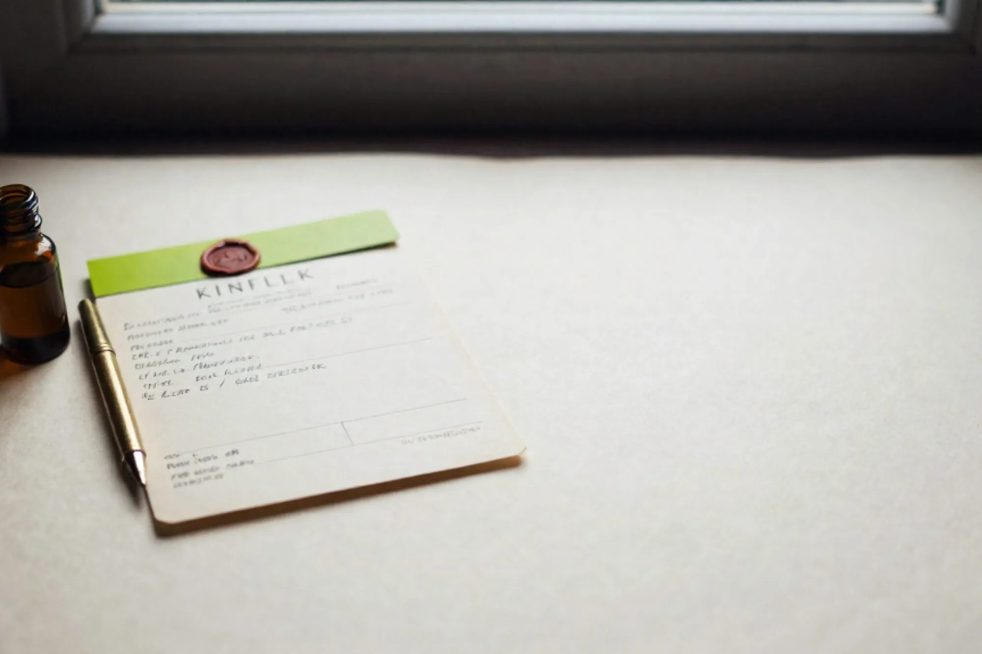 Weathered prescription pad with green tab, brass fountain pen, amber vial on ivory paper, side window light.