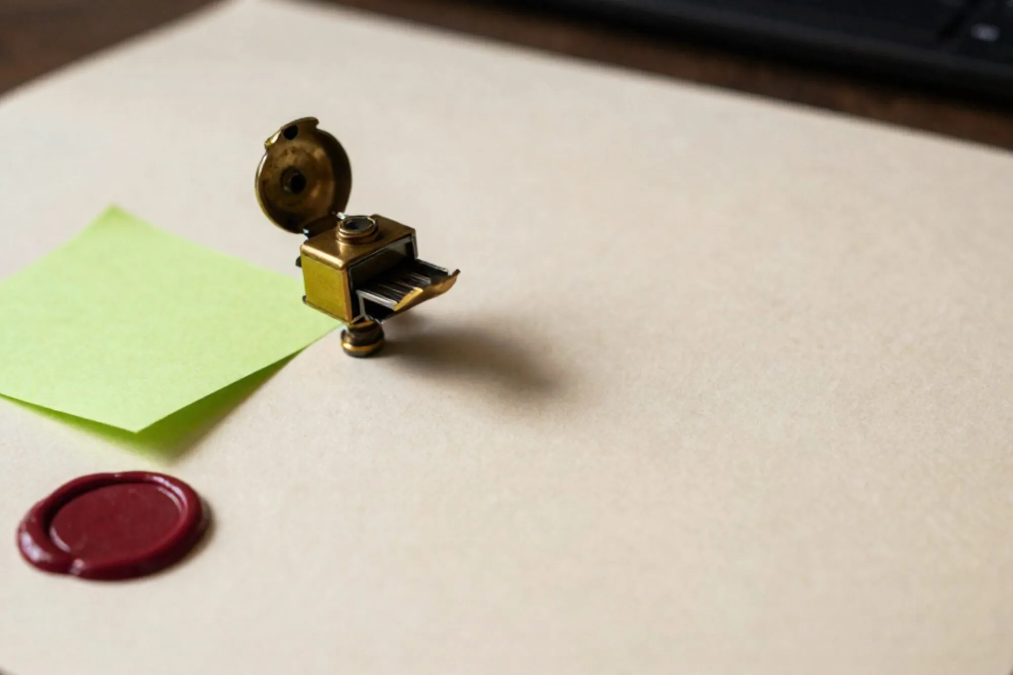 Antique brass relay switch open beside a sealed cream form with green sticky note and broken red wax seal on ivory paper.