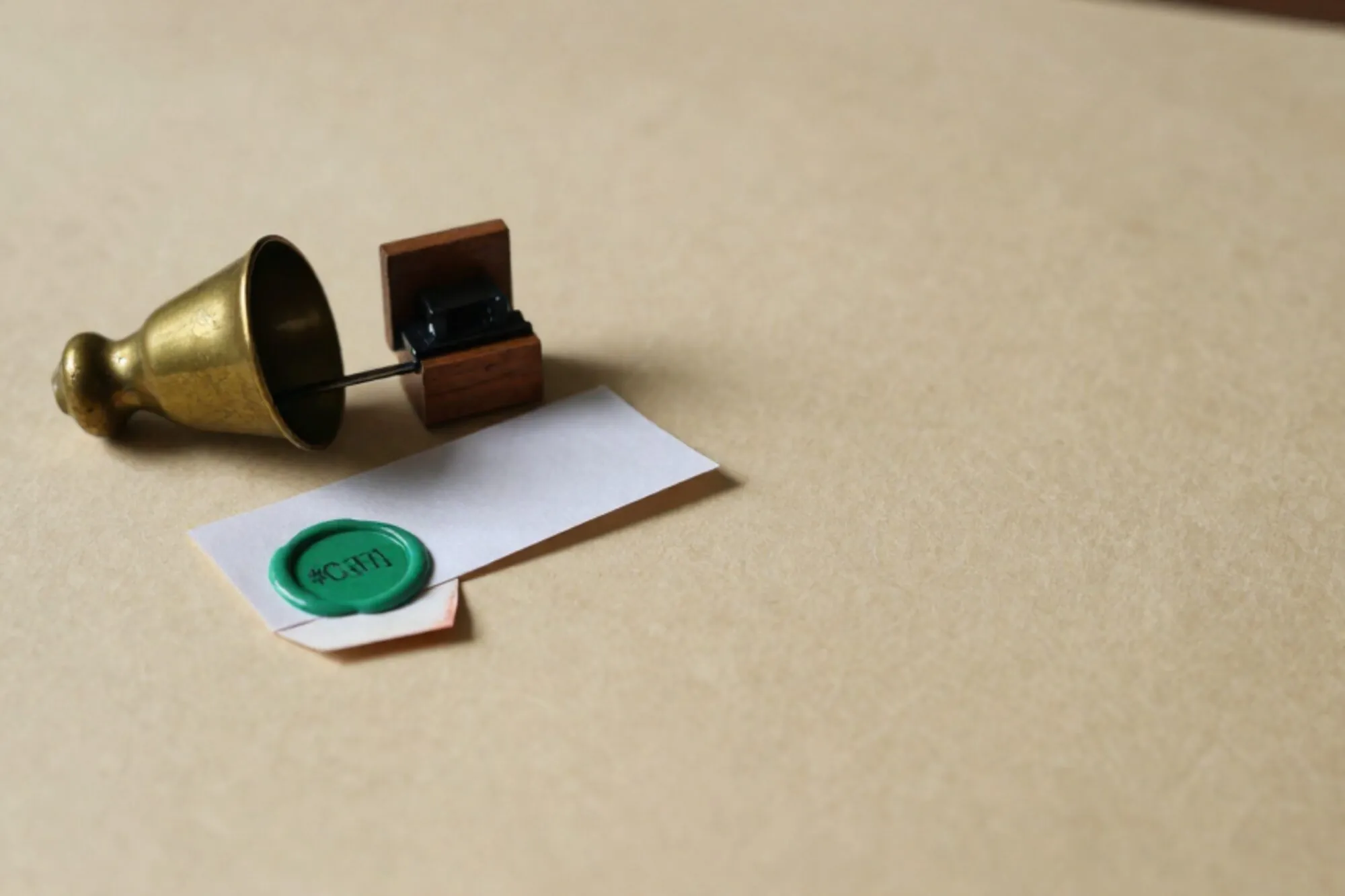 Messing buispostkoker, klein houten relaisschakelaartje, gevouwen papierstrookje met groen lakzegel op ivoor papier.