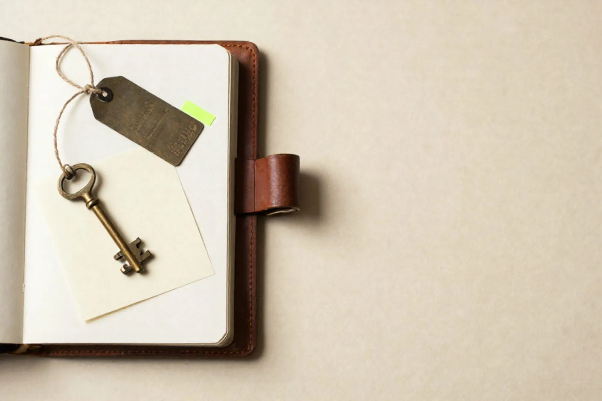 Open leren logboek, koperen sleutel op crème kaart, ijzeren label met touw, groen tabblad, rode lakzegel op ivoor papier.