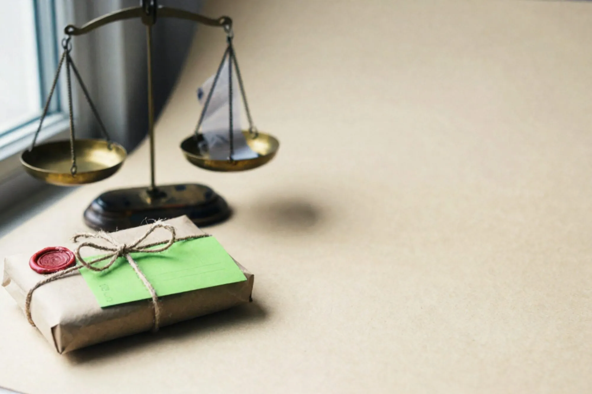 Brass scale, twine-tied paper parcel, chartreuse postcard, red wax seal on ivory paper near a window.