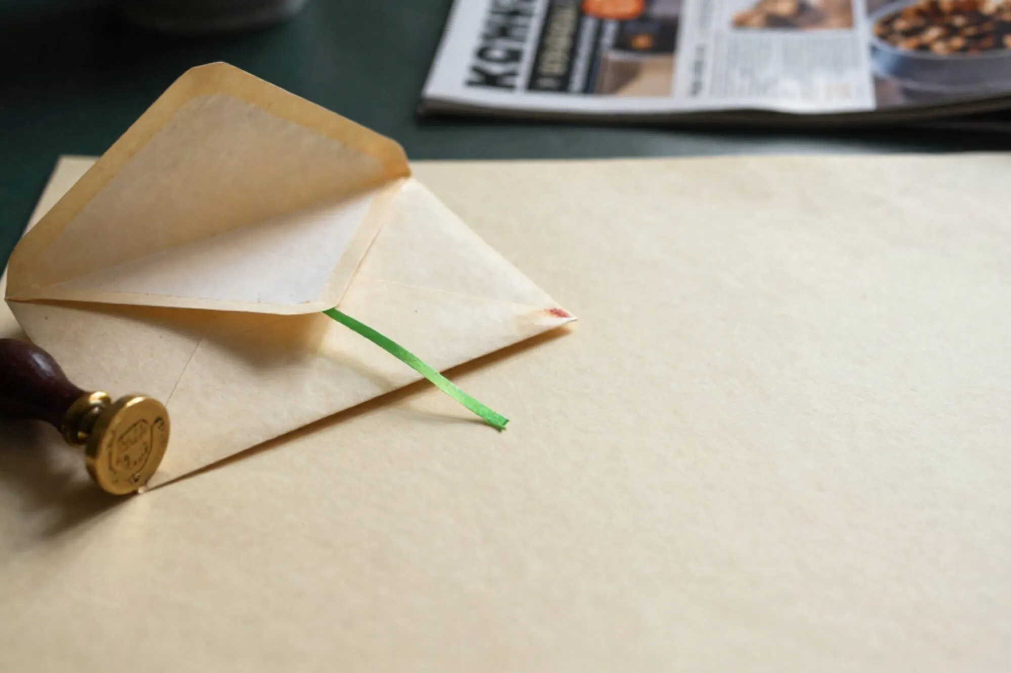 Unsealed manila envelope on ivory paper with chartreuse ribbon, brass wax stamp, carbon-copy form, red ink smudge.
