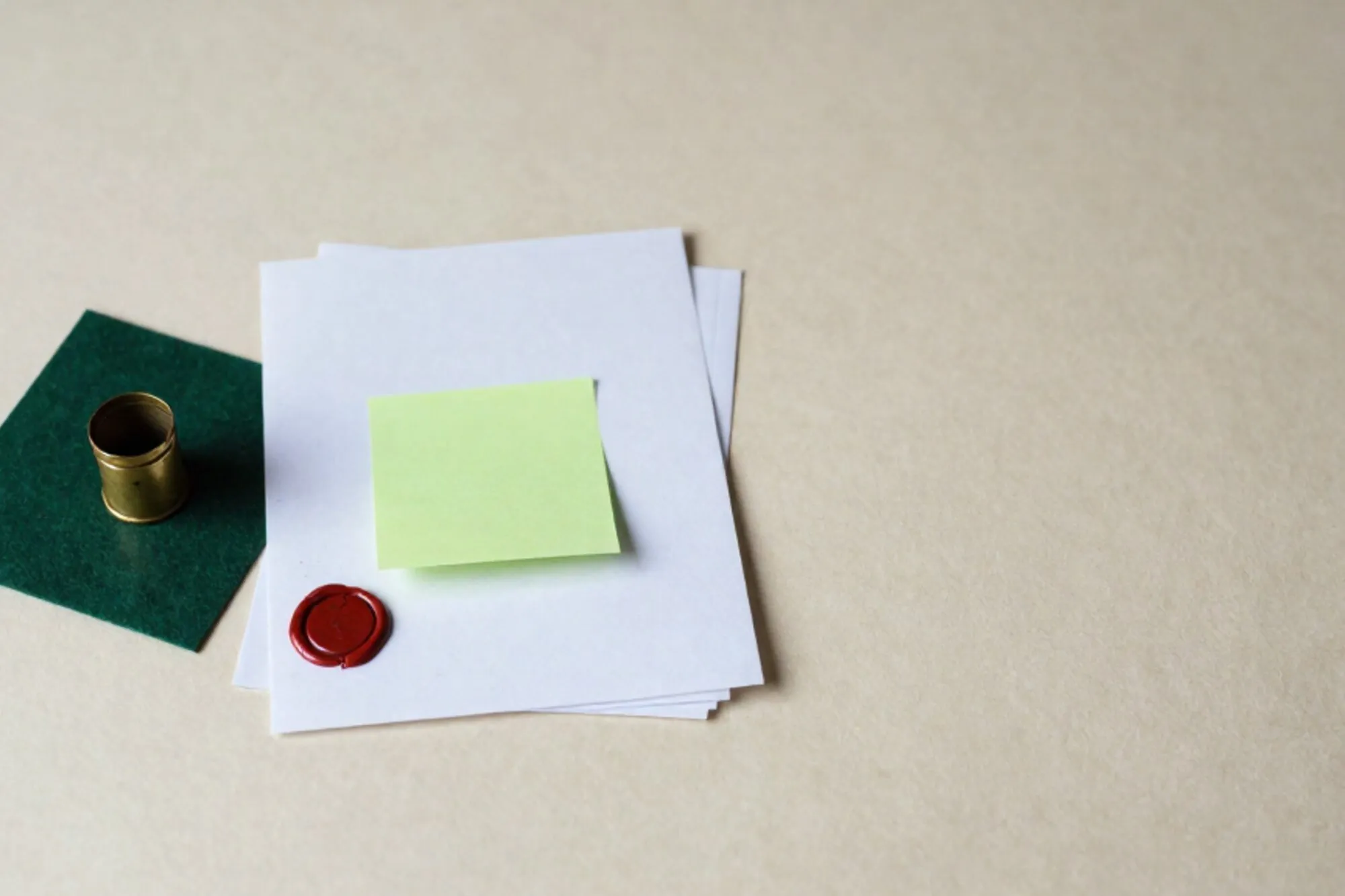 Brass pneumatic tube capsule, paper form with carbon copies, chartreuse sticky note, wax seal on green felt blotter.